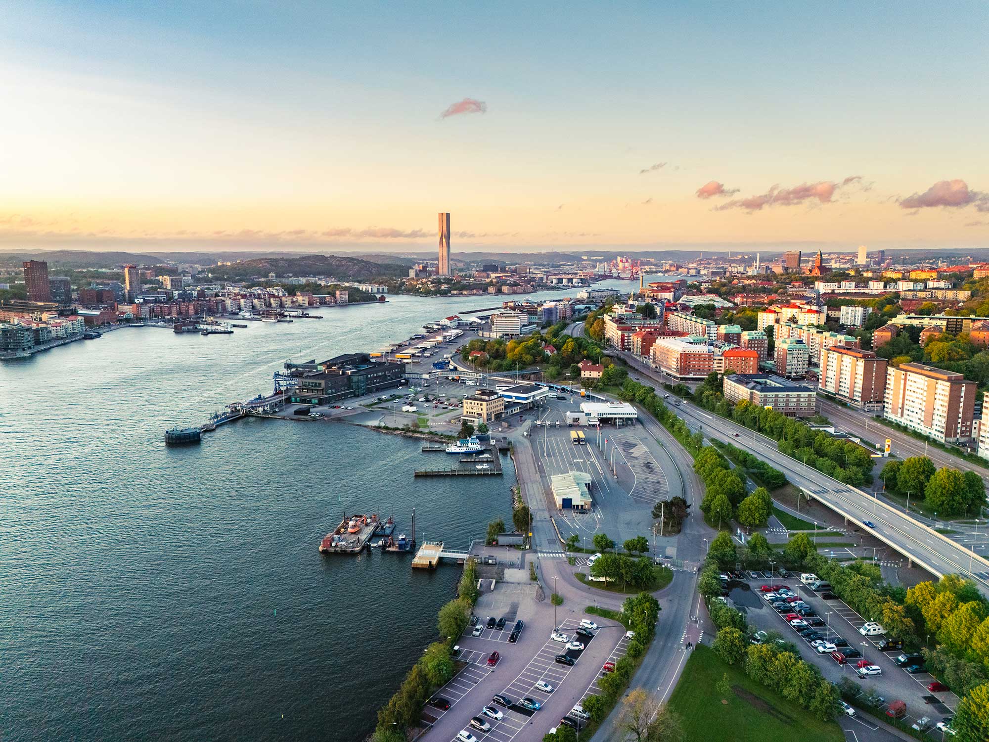 En drönarbild över Göteborg med hamnområde, flod och bostadsområden